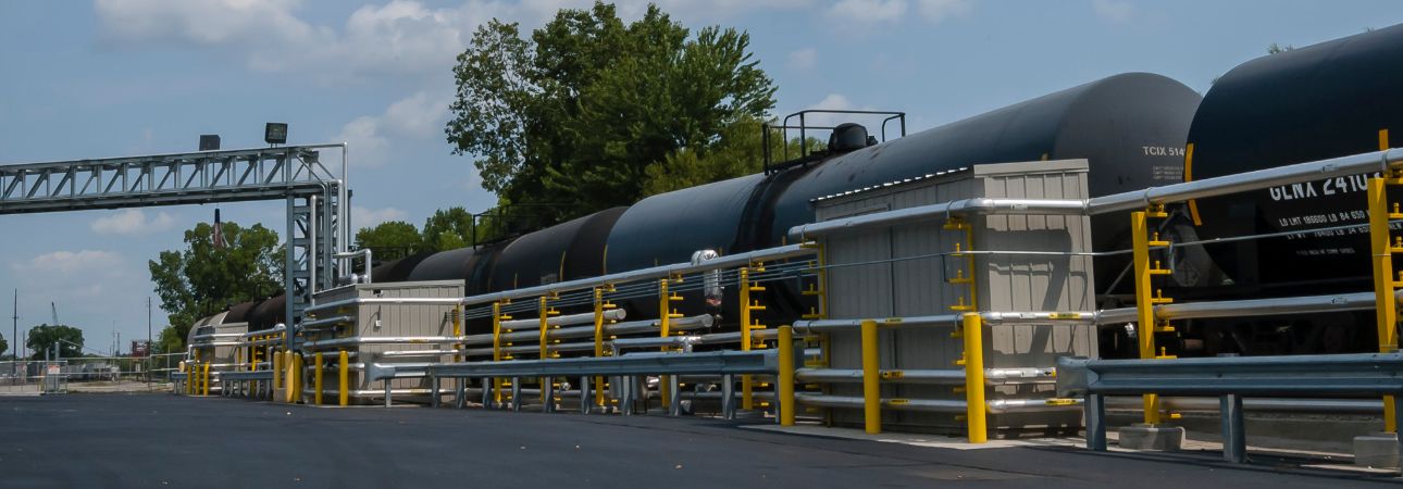 Tank railcars are lined up in a facility loading dock. 